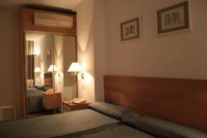a hotel room with a bed and a mirror at Hotel el Paraiso in Caleta De Velez