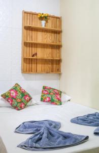 a bed with two pillows and towels on it at KM Hostel in Porto De Galinhas