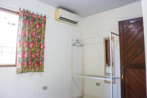 una habitación con una cortina en la pared y una ventana en KM Hostel, en Porto de Galinhas