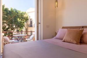 a bedroom with a bed and a balcony with a table at Suite Cagliari in Cagliari