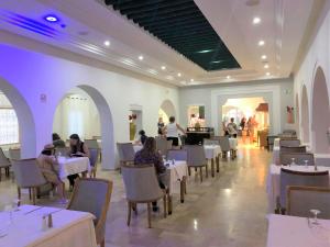 uma sala de jantar com pessoas sentadas às mesas em Zenon Djerba em Midoun