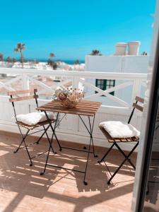d'une table en bois et de deux chaises sur un balcon. dans l'établissement Casa Rosalia Puerto del Carmen, à Puerto del Carmen