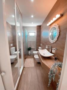 ein Badezimmer mit einem Waschbecken, 2 WCs und einem Spiegel in der Unterkunft Casa Rosalia Puerto del Carmen in Puerto del Carmen