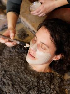 um homem com uma máscara na cara como uma pessoa a cortar-lhe a cara em Golden Haven Hot Springs em Calistoga