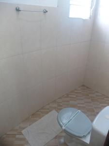 a bathroom with a toilet and a shower at Pousada Edson in Caraguatatuba