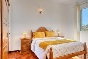 a bedroom with a bed and a dresser and a window at Casa do Valentim, a Home in Madeira in Ponta do Sol