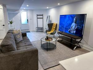 a living room with a couch and a flat screen tv at New & Renovated Spacious 2BR Apt in Thornhill in Vaughan