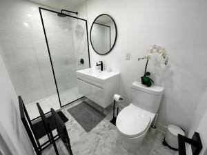 a bathroom with a toilet and a sink and a mirror at New & Renovated Spacious 2BR Apt in Thornhill in Vaughan