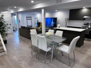 a dining room and living room with a table and white chairs at New & Renovated Spacious 2BR Apt in Thornhill in Vaughan