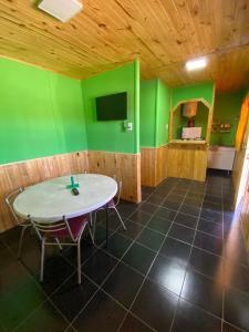 Habitación con mesa y pared verde. en Cabañas EL SOLEADO en Zonda