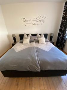 1 dormitorio con 1 cama grande con sábanas y almohadas blancas en Gemütliche Fewo mit Garten, en Eisenach