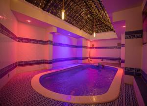 uma banheira de hidromassagem num quarto com iluminação roxa em Yar Furnished Apartments em Jazan