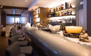 Un bar en un restaurante con un mostrador y sillas. en Golden Park Resort, en Campitello di Fassa