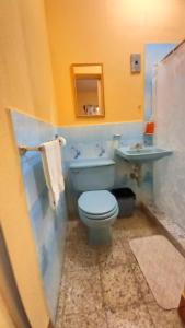 a bathroom with a blue toilet and a sink at Hotel Maya America in Panajachel