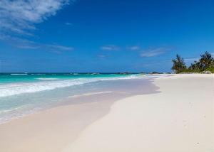 - une plage de sable blanc avec l'océan et l'eau dans l'établissement Ananda House estate, à Governorʼs Harbour