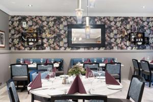 a dining room with tables and chairs and floral wallpaper at Best Western Plus Gyldenlove Hotell in Kongsberg