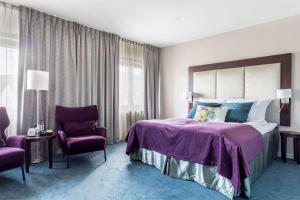 康斯博的住宿－基登拉弗貝斯特韋斯特優質酒店，一间卧室配有一张大床和两把椅子