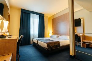 Llit o llits en una habitació de Best Western Hotel Tre Torri