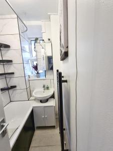 a white bathroom with a sink and a mirror at The Headlam Apartment in London
