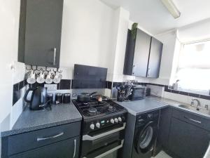 a kitchen with a black stove and a sink at The Headlam Apartment in London