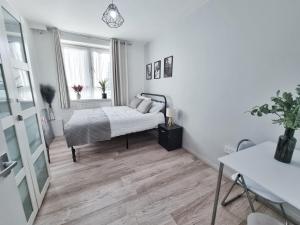 biała sypialnia z łóżkiem i oknem w obiekcie The Headlam Apartment w Londynie