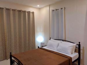 a bedroom with a bed with white pillows at Casa LeoMa in Cavite