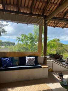 a porch with a bench and a view of the forest at Pousada Céu de Corumbau in Corumbau