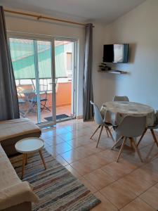 een woonkamer met een tafel, stoelen en een televisie bij Maremy in Zadar