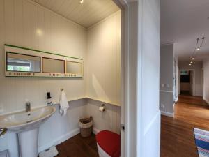 a bathroom with a sink and a red stool at Hot Water Beach Escape in Hotwater Beach