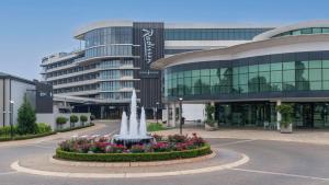 ein großes Gebäude mit einem Brunnen davor in der Unterkunft Radisson Hotel & Convention Centre Johannesburg, O.R. Tambo in Johannesburg