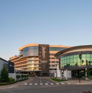 un grand bâtiment avec une rue en face dans l'établissement Radisson Hotel & Convention Centre Johannesburg, O.R. Tambo, à Johannesbourg