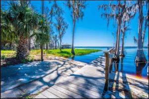 a boardwalk with palm trees and a body of water at Beautiful cottage near Lake Louisa & mins from Disney, Vehicle Rental Available in Clermont