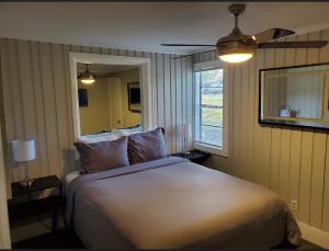a bedroom with a large white bed with a ceiling fan at Beautiful cottage near Lake Louisa & mins from Disney, Vehicle Rental Available in Clermont