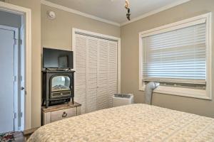a bedroom with a bed and a tv and a window at Chic Oceanfront North Topsail Beach Condo with Deck in North Topsail Beach