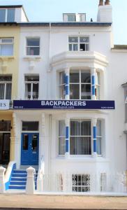 a white building with a blue sign on it at Backpackers Blackpool - Family Friendly Hotel in Blackpool