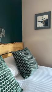 Arosfa Harbourside Guesthouse في أبيريرون: سرير عليه وسادتين في غرفة النوم