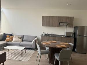 a kitchen and a living room with a table and a couch at Departamento Tipo Loft, zona ajijic. in Jocotepec