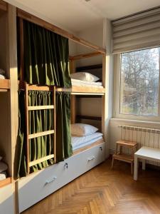 Zimmer mit 2 Etagenbetten und einem Fenster in der Unterkunft Cabbage Hostel in Belgrad