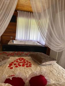 a bedroom with a bed with roses on it at Pousada Olho d'água in Rio Rufino