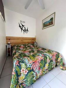 1 dormitorio con 1 cama con una manta colorida en Appartement vue mer en Le Moule