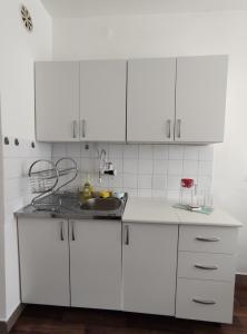 a white kitchen with white cabinets and a sink at Charming & Spacious 2 Bedroom Apartment with a Gorgeous 8th-floor view in Ohrid