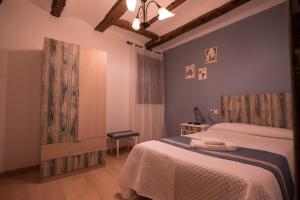 Un dormitorio con 2 camas y una silla. en Masía Nicolás, en Cella