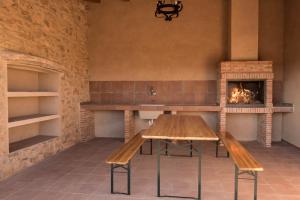 a dining room with a table and a fireplace at Masía Nicolás in Cella