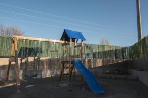 un parque infantil con un tobogán azul y un columpio en Masía Nicolás, en Cella