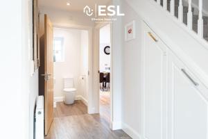 a white hallway with a toilet and a staircase at Large Modern 4 Bedroom House in Uttoxeter, Near Alton Towers, Great for Families in Uttoxeter +42 photos