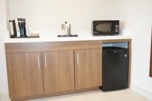 a kitchen with a counter with a microwave and a refrigerator at Holiday Inn Express Fremont - Milpitas Central, an IHG Hotel in Fremont