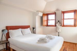 um quarto com uma cama branca e toalhas em Citybreak-apartments Douro View no Porto