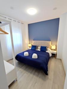 una camera blu con un grande letto con due cuscini di Sol Rastro a Úbeda