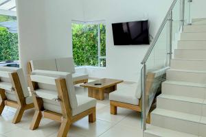 a living room with a table and a tv and stairs at Condo Apulo - Hermosa casa - Jacuzzi y Piscina privados - WiFi in Apulo