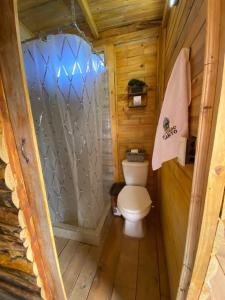 a bathroom with a toilet in a wooden cabin at El Refugio del Santo 